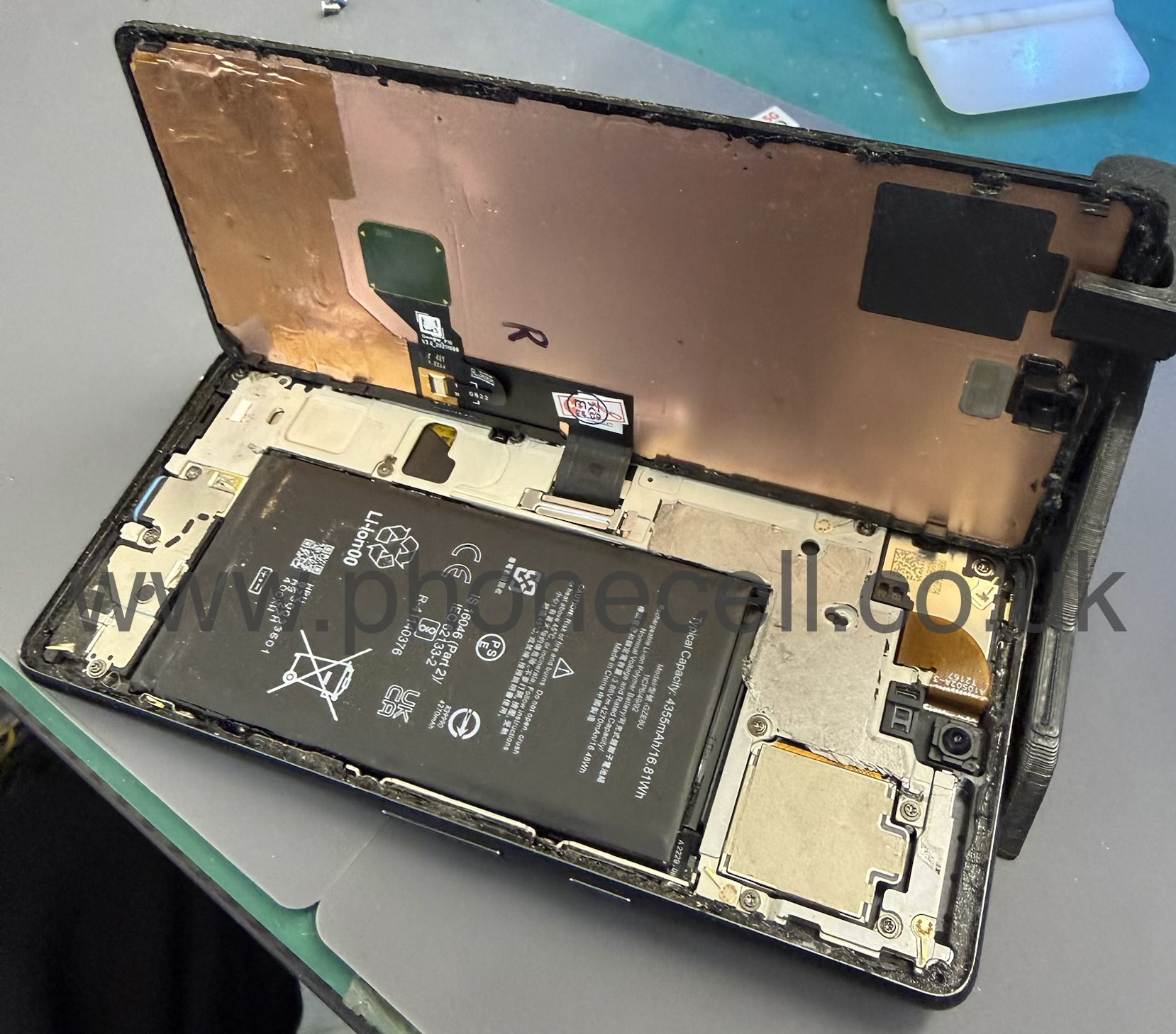 Phone opened for repair showing internal battery and display assembly